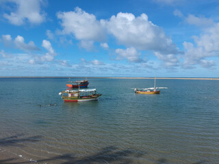 scenic view of a seaside with two fishing boats in the middle under the cloudy sky