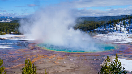 Sticker - Beautiful view of a pond with steam on the background of fir trees and hills in winter