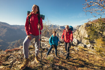 father with two kids hiking in mountains