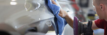 Man Repairman Wiping Car With Microfiber Cloth And Holding Polishing Machine In His Hand Closeup