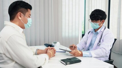 Wall Mural - Doctors are explaining the treatment of a sick patient in tablets while wearing a mask during the virus outbreak.