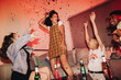 © Jacob Lund - Cheerful young woman dancing with her freinds at a party