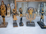 Fototapeta Tęcza - Stone statuettes of Egyptian gods on display in a souvenir shop. Selective focus. Luxor, Egypt.