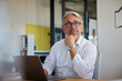 © Westend61 - Contemplative mature businessman with laptop sitting in office