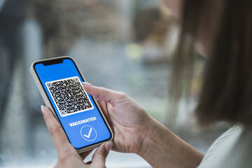 Young woman with vaccination QR code on smart phone screen