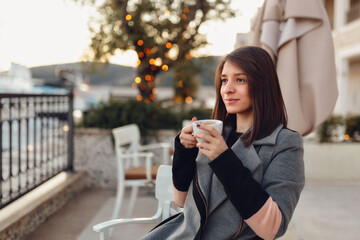 Sticker - Young Caucasian female having a morning coffee in an outdoor cafe in Montenegro