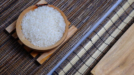 Rice in an oval wooden bowl and some kitchen ornaments neatly and beautifully arranged on a table. food and beverage concept. 