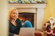 Photo of sad businesswoman working at her home for Christmas holidays. Young woman in christmas interior with laptop ( negative emotions). Exhausted young woman working at home