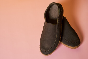 Poster - Closeup shot of a pair of male shoes on a pink background