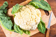 Cauliflower on a kitchen wooden cutting board, top view, close-up