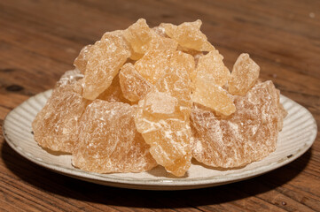 The rock sugar in the container is on the wood grain table