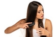 © vladimirfloyd - Young woman brushing her long straight hair on a white background