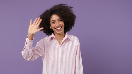 Wall Mural - Back rear view happy young black woman 20s years old wears pink shirt turn around camera waving meet greet with hand as notices someone isolated on plain pastel light purple background studio portrait