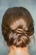 © okskukuruza - Rearview of young brunette woman with beautiful middle bun hairstyle on gray background