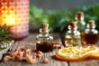 A bottle of myrrh essential oil with myrrh resin, orange and fir in the background