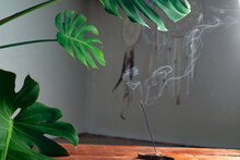 Smoke From An Incense Stick On The Background Of An Interior With Indoor Plants And Dream Catchers. Meditation And Mental Health Concept