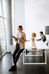 Young woman holding digital tablet and working in modern office