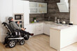 © pressmaster - Middle aged man with disability sitting by electric oven in large comfortable kitchen in home environment