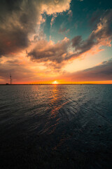 Wall Mural - vertical shot of the beautiful sunset above the sea. oosterscheldekering, the netherlands.