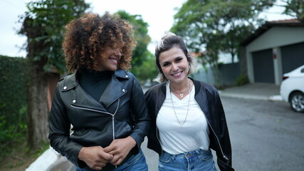 Two women walking together in street. diversity concept, female friends walk outside