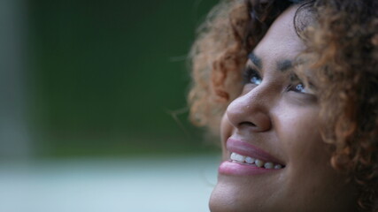 Black woman closing eyes during drizzle day. close-up Brazilian girl face opening eye to sky with HOPE