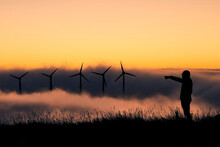 Sunset At The Wind Farm Over A Beautiful Sea Of ​​clouds