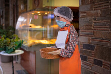 Mannequin Man Infront Of Bakery Holding Basquet, Wearing A Protective Blue Face Mask. Virus Protection And Prevention Concept.Quarantine, Respiratory Protection. Requirement To Wear Masks.