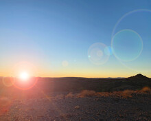 Old West Sunset Lens Flair Setting Sun Over Desert Mountains