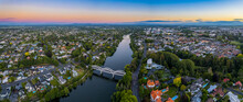 Aerial Drone Panoramic View At Sunset, Looking Up The Waikato River Towards The CBD, Over The City Of Hamilton (Kirikiriroa) In The Waikato Region Of New Zealand.