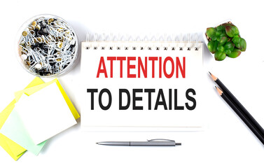 Poster - ATTENTION TO DETAILS text on notebook with office supplies on white background