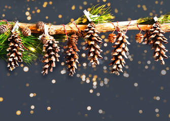 Wall Mural - Christmas decor of pine cones on dark background. Christmas greeting card with place for your text.