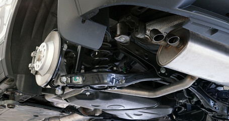 Wall Mural - Modern car in a car service on a lift during repairs. The rear wheel is removed from the machine. Selected focus.