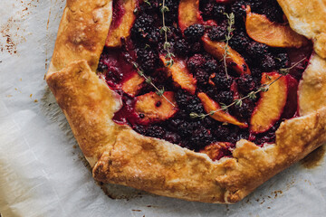 Sticker - peach, blackberry, thyme galette close up on parchment paper right out of the oven