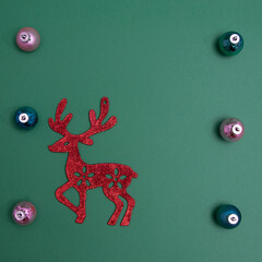 Poster - Christmas decorations in various colors with red reindeer on a green background with copy space