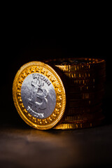 Wall Mural - Closeup of a crypto currency business next to a bitcoin coins line with a black background