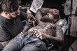 © Mr. Prof - Tattoo master makes tattoo in tattoo studio