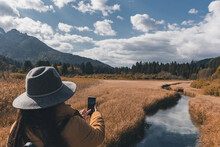 Woman Taking Photos Of Autumn Landscape At Zelenci Nature Reserve In Slovenia