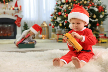 Wall Mural - Cute little boy with toy car in room decorated for Christmas