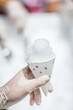 Holding a snow cone in a paper cup with gloves