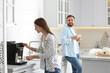© New Africa - Beautiful young woman and her boyfriend using modern coffee machine in kitchen