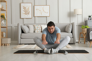 Sticker - Overweight man stretching on mat at home