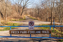 A No Parking Sign On A Gate With A Wooden Sign For The Frick Park Firelane Trail In Frick Park In Pittsburgh, Pennsylvania, USA On A Sunny Winter Day