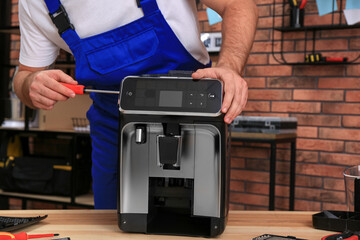 Sticker - Repairman with screwdriver fixing coffee machine at table indoors, closeup