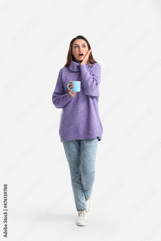 Surprised woman with cup of coffee on white background