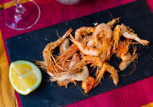 Crispy Battered Shrimps Served With Lime On Black Plate