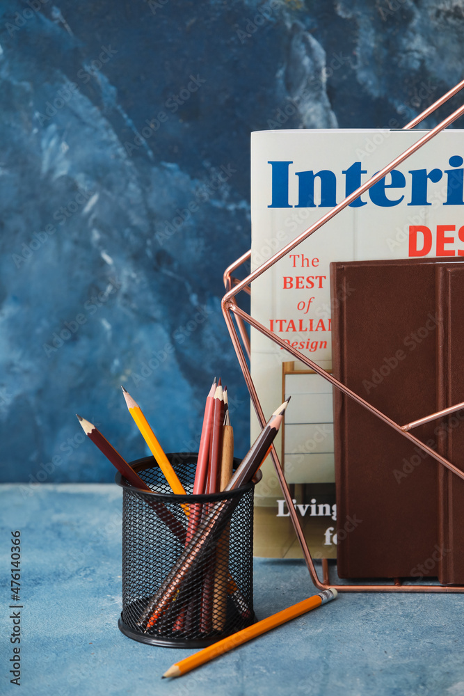 Organizer with books and stationery on color background