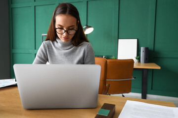 Canvas Print - Female notary public working on laptop in office