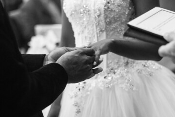 Canvas Print - Closeup of a man holding his bride's hand at their wedding