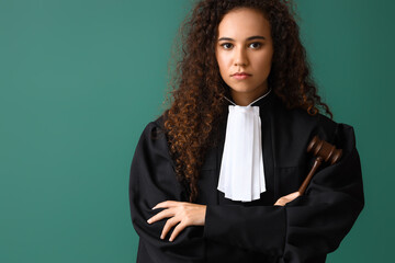 Poster - Young female judge with gavel on color background