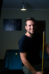 Poster - Closeup shot of a Hispanic male playing billiard in a bar in Argentina